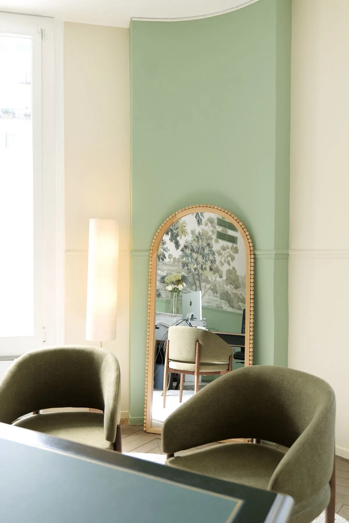 Carnot — salle d'attente avec miroir arqué en bois et fauteuils verts, Atelier Nola