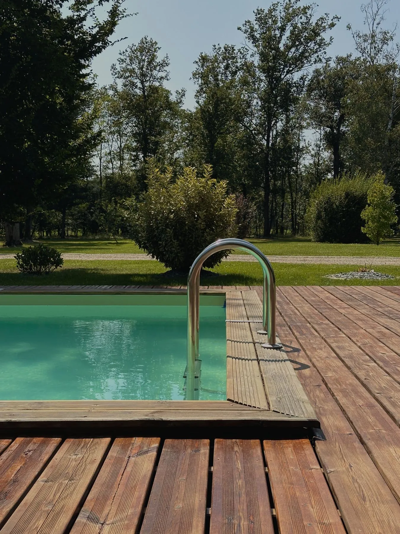 Milasson — échelle de piscine et terrasse en bois avec vue sur le jardin, Atelier Nola