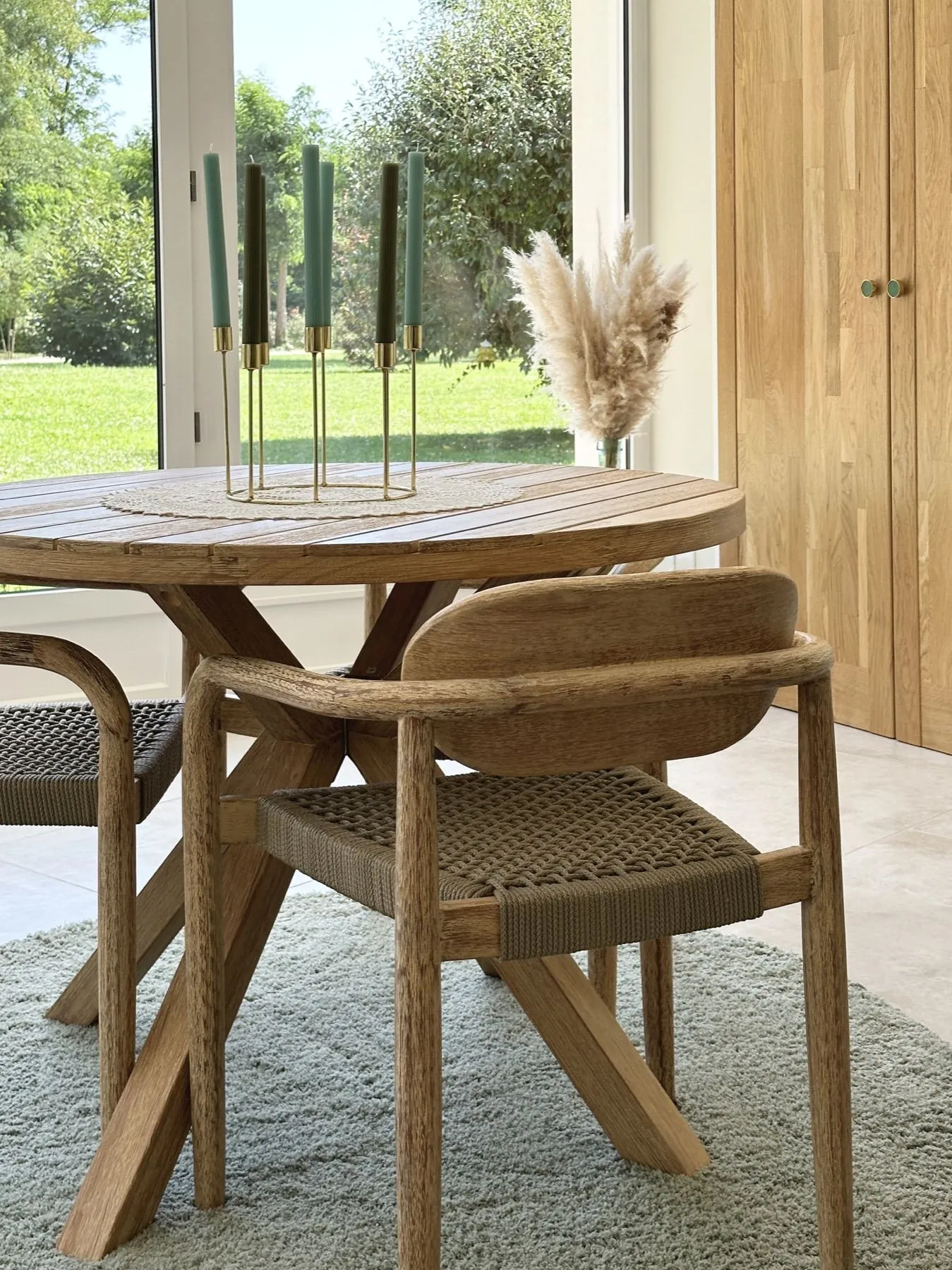 Sèves 1 — table ronde, chandelier vert et baie vitrée sur le jardin, Atelier Nola