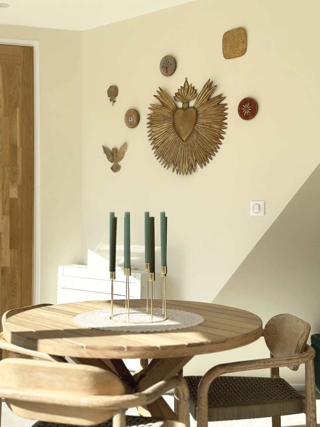 Sèves 1 — table ronde en bois avec chandelier vert devant les portes en chêne, Atelier Nola