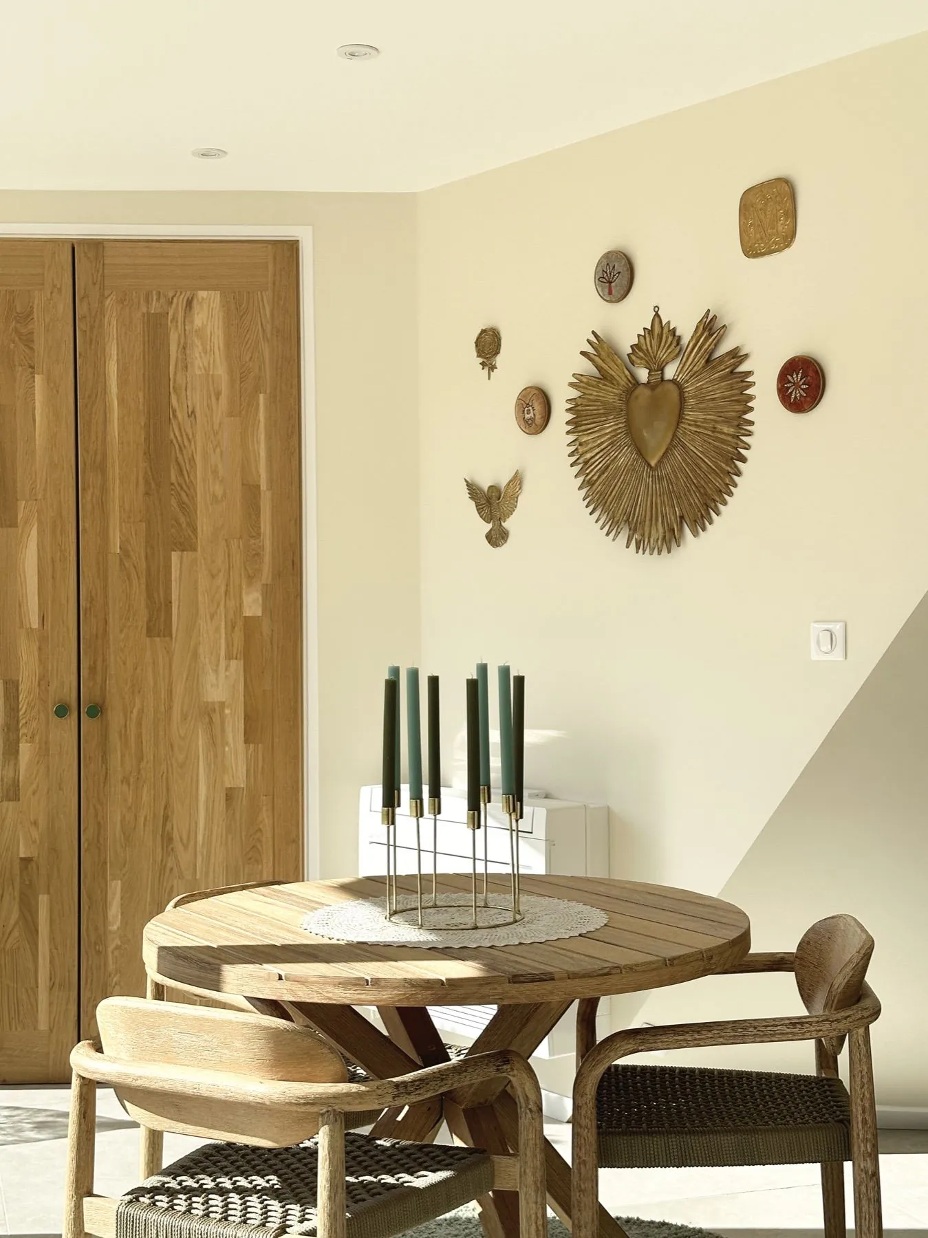 Sèves 1 — pièce d'entrée avec table ronde en bois et décorations murales dorées, Atelier Nola