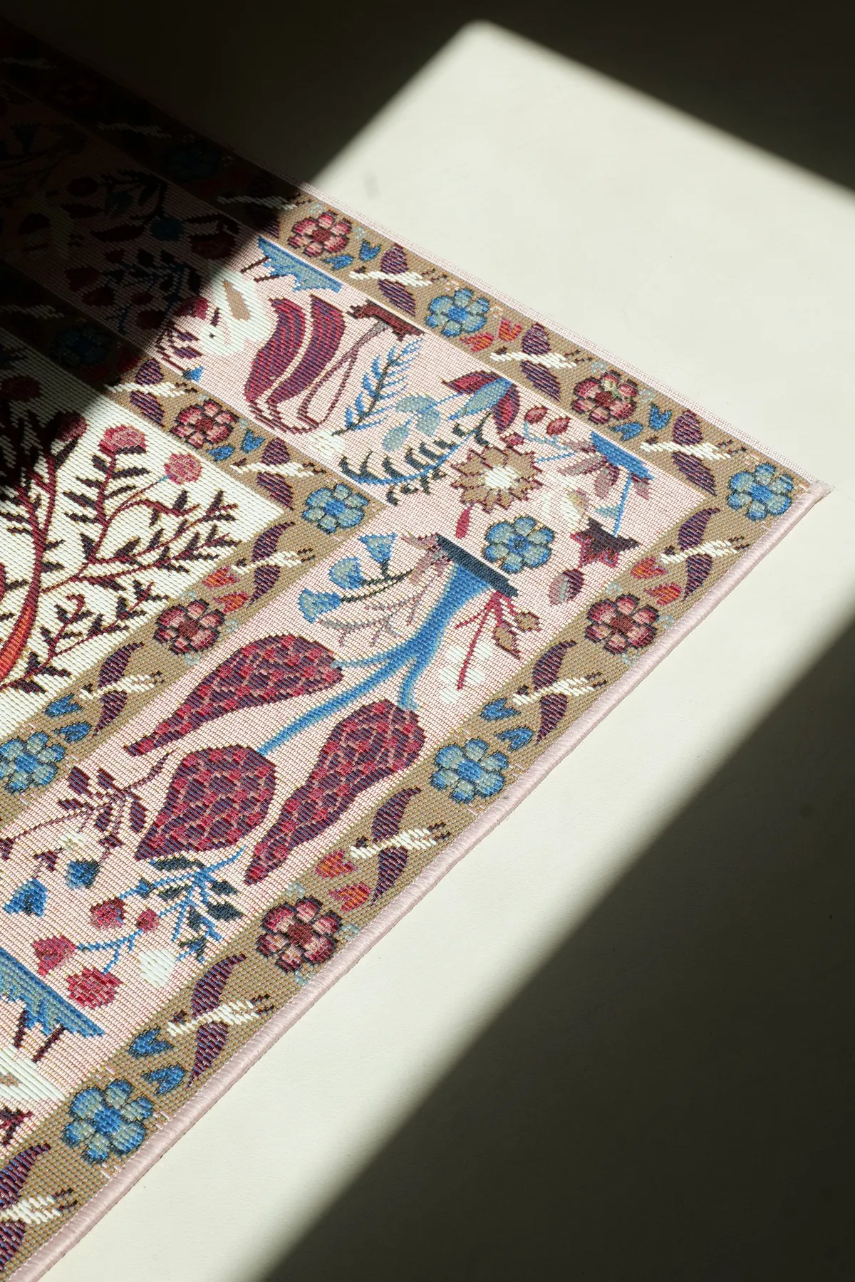 Sèves 2 — détail du tapis à motifs floraux sous un rayon de lumière, Atelier Nola